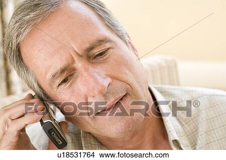 Man indoors using cellular phone View Large Photo Image Picture - Man indoors using cellular phone. Fotosearch