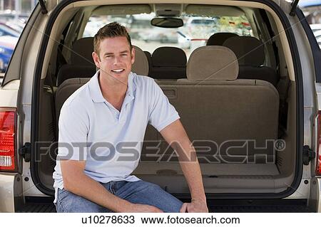 Man sitting in back of van smiling View Large Photo Image Stock Image - Man sitting in back of van smiling. Fotosearch