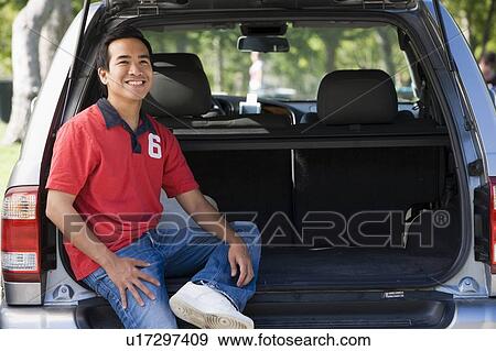 Man sitting in back of van smiling View Large Photo Image Stock Photo - Man sitting in back of van smiling. Fotosearch