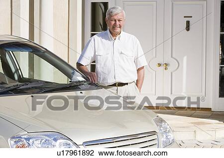 Senior man standing with his car outside his home View Large Photo Image Stock Image - Senior man standing with his car outside his home. Fotosearch