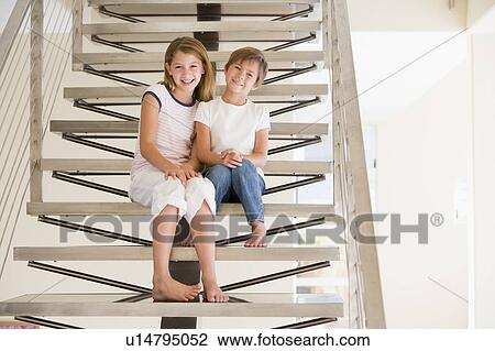 Two Young Girls Sitting On A Staircase At Home View Large Photo Image Stock Image - Two Young Girls Sitting On A Staircase At Home. Fotosearch