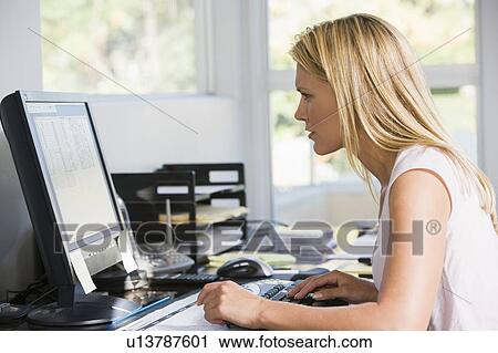 Stock Image - Woman in home office with computer. Fotosearch