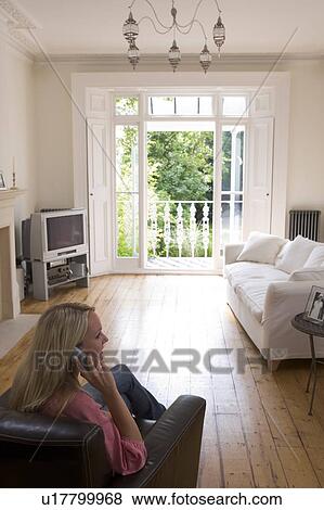 Woman in living room talking on telephone View Large Photo Image Stock Photo - Woman in living room talking on telephone. Fotosearch