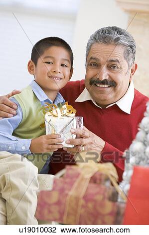 Boy Surprising Father With Christmas Present View Large Photo Image Stock Image - Boy Surprising Father With Christmas Present. Fotosearch