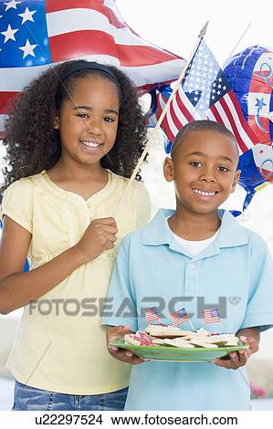 Brother and sister on fourth of July with flag and cookies smiling View Large Photo Image Picture - Brother and sister on fourth of July with flag and cookies smiling. Fotosearch