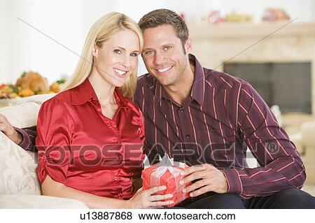 Couple Sharing Christmas Present View Large Photo Image Stock Photo - Couple Sharing Christmas Present. Fotosearch