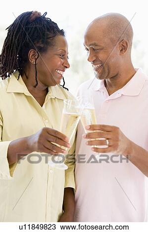 Couple toasting champagne and smiling View Large Photo Image Stock Image - Couple toasting champagne and smiling. Fotosearch