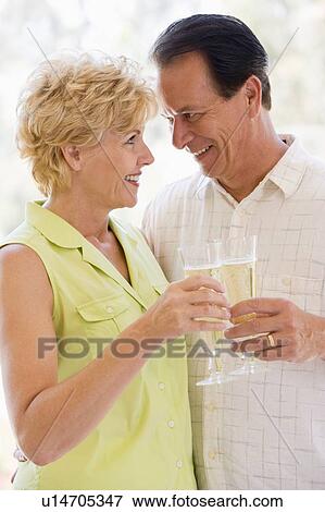 Couple toasting champagne and smiling View Large Photo Image Stock Photo - Couple toasting champagne and smiling. Fotosearch