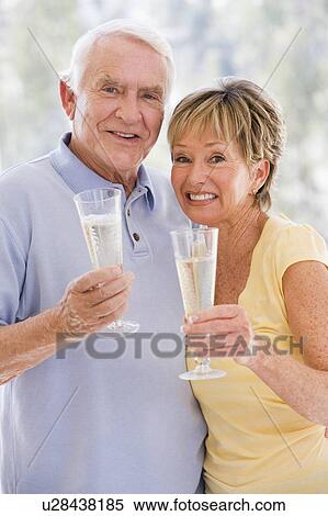 Couple toasting champagne and smiling View Large Photo Image Stock Photography - Couple toasting champagne and smiling. Fotosearch