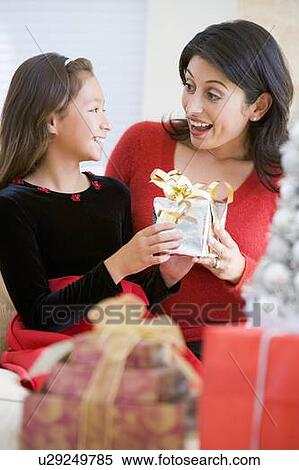 Girl Surprising Her Mother With Christmas Gift View Large Photo Image Stock Photography - Girl Surprising Her Mother With Christmas Gift. Fotosearch