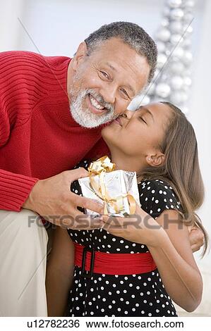 Stock Photograph - Grandfather Giving His Granddaughter A Christmas Present. Fotosearch
