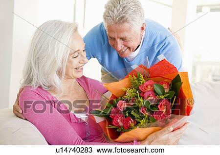 Husband giving wife flowers and smiling View Large Photo Image Stock Image - Husband giving wife flowers and smiling. Fotosearch