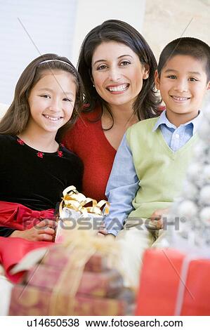 Stock Photo - Mother With Her Son And Daughter Holding Christmas Gifts. Fotosearch