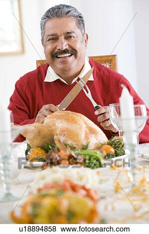 Stock Photo - Senior Man Excitedly Getting Ready To Carve The Turkey. Fotosearch