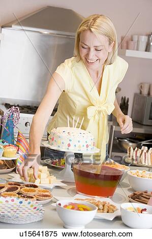 Woman at party getting tart from food table smiling View Large Photo Image Stock Photography - Woman at party getting tart from food table smiling. Fotosearch