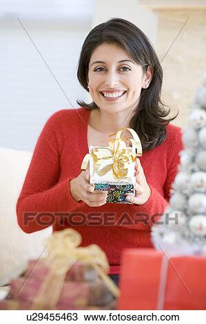 Stock Image - Woman Excited To Open Christmas Present. Fotosearch