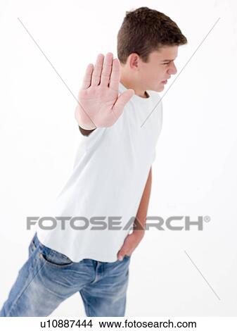 Picture - Teenage boy standing with hand up. Fotosearch