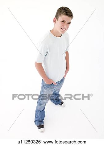 Stock Photograph - Teenage boy standing with hands in pockets. Fotosearch