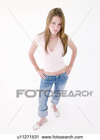 Stock Image - Teenage girl with hands on hips frowning. Fotosearch