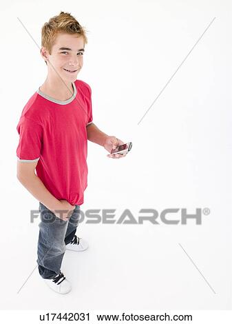Stock Image - young boy holding cellular phone and smiling. Fotosearch