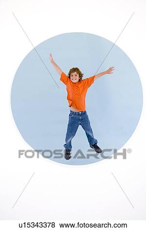Stock Photo - Young boy jumping with arms out smiling. Fotosearch