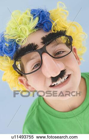 Stock Photography - Young boy wearing clown wig and fake nose. Fotosearch