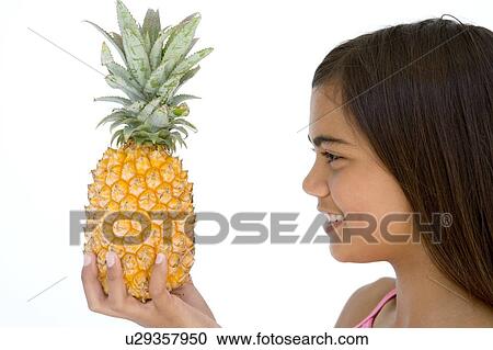 Young girl holding pineapple and smiling View Large Photo Image Stock Image - Young girl holding pineapple and smiling. Fotosearch