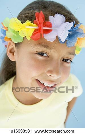 Stock Image - Young girl wearing garland on head smiling. Fotosearch