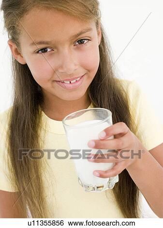 Stock Photograph - Young girl with glass of milk smiling. Fotosearch