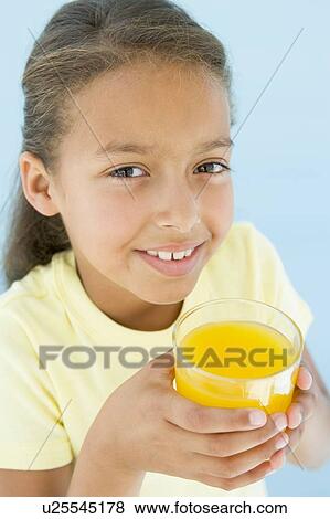 Young girl with glass of orange juice smiling View Large Photo Image Stock Photo - Young girl with glass of orange juice smiling. Fotosearch