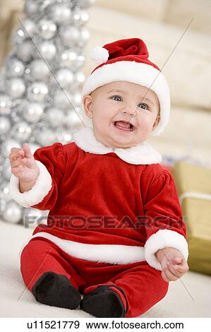 Stock Photo - Baby In Santa Costume At Christmas. Fotosearch