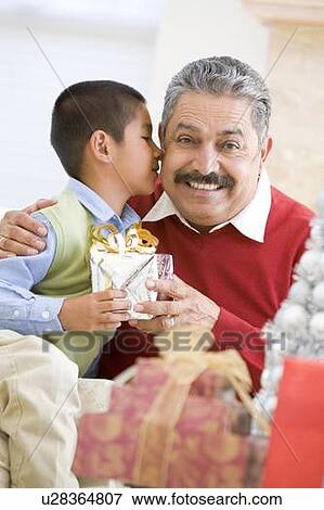 Stock Photo - Boy Surprising Father With Christmas Present. Fotosearch