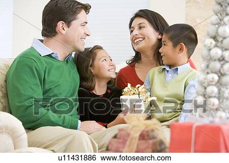 Family Smiling At Each Other, Holding Christmas Gift View Large Photo Image Stock Photograph - Family Smiling At Each Other, Holding Christmas Gift. Fotosearch
