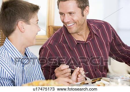 Stock Image - Father And Son At Christmas Dinner. Fotosearch