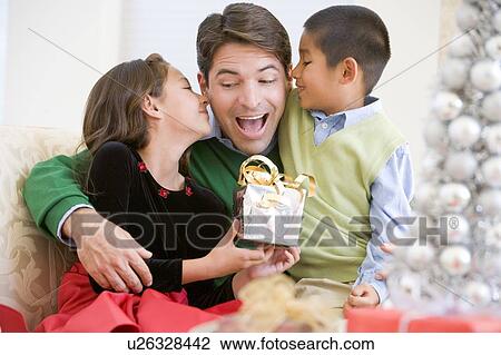 Father Being Given A Christmas Present By His Daughter And Son View Large Photo Image Stock Image - Father Being Given A Christmas Present By His Daughter And Son. Fotosearch