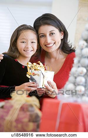 Girl Surprising Her Mother With Christmas Gift View Large Photo Image Stock Photograph - Girl Surprising Her Mother With Christmas Gift. Fotosearch