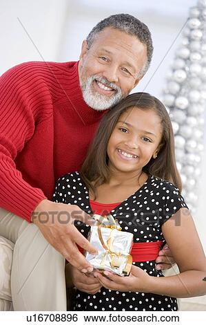 Grandfather Giving His Granddaughter A Christmas Present View Large Photo Image Stock Photograph - Grandfather Giving His Granddaughter A Christmas Present. Fotosearch