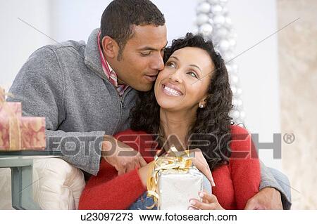 Husband And Wife Affectionately Exchanging Christmas Gifts View Large Photo Image Stock Image - Husband And Wife Affectionately Exchanging Christmas Gifts. Fotosearch