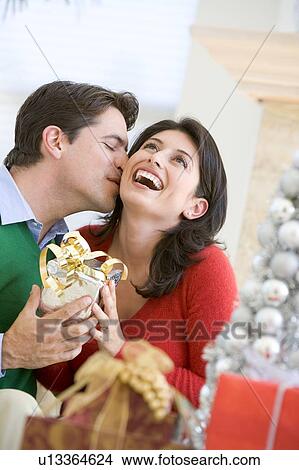 Picture - Husband Surprising Wife With Christmas Present. Fotosearch