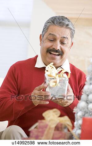 Stock Photo - Man Excited To Open Christmas Present. Fotosearch