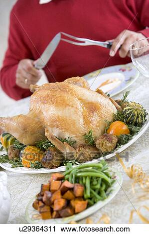 Stock Image - Man Preparing To Carve A Turkey. Fotosearch