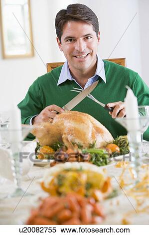 Stock Photography - Man Preparing To Carve A Turkey. Fotosearch