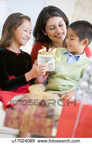Mother Sitting With Her Son And Daughter, Exchanging Christmas Gifts View Large Photo Image Stock Photo - Mother Sitting With Her Son And Daughter, Exchanging Christmas Gifts. Fotosearch
