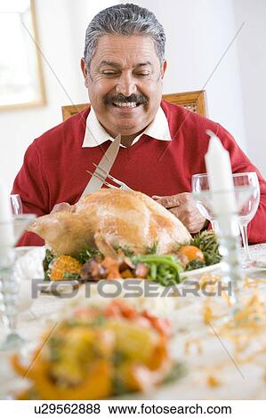 Stock Photo - Senior Man Excitedly Getting Ready To Carve The Turkey. Fotosearch