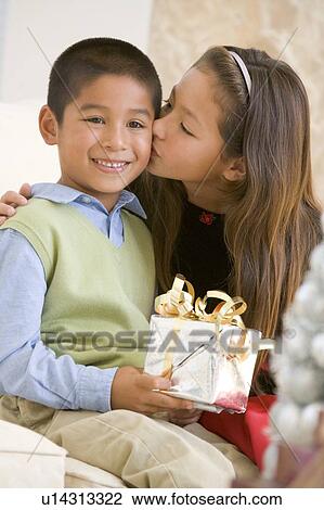 Sister Giving Her Brother A Christmas Present And Kissing Him On The Cheek View Large Photo Image Stock Image - Sister Giving Her Brother A Christmas Present And Kissing Him On The Cheek. Fotosearch