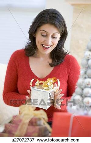 Stock Photo - Woman Excited To Open Christmas Present. Fotosearch