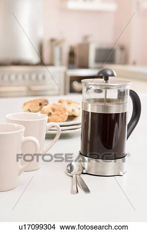 Picture - Coffee pot on kitchen counter with scones. Fotosearch