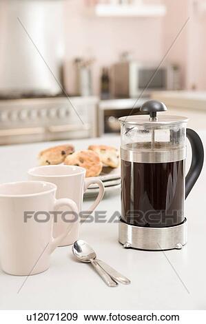 Stock Photo - Coffee pot on kitchen counter with scones. Fotosearch