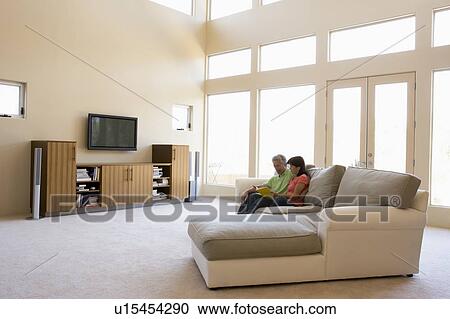 Couple reading book in living room View Large Photo Image Stock Image - Couple reading book in living room. Fotosearch