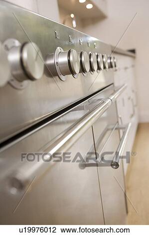 Stock Image - Empty kitchen with focus on stove dials. Fotosearch